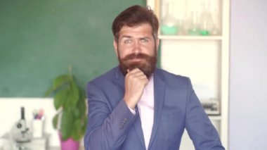 Erkek Üniversite Öğrencisi'nin kapalı mekandaki portresi. Bilgi günü. Öğrenci ve özel eğitim kavramı. Sınava veya sınava hazırlanan öğrenci. Tahta arka plan da sınıfta Profesör.