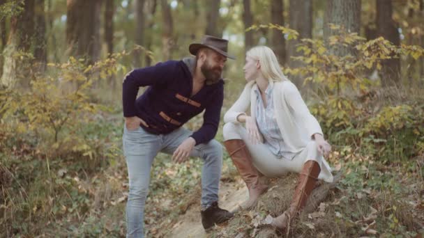 Pareja joven posando en Trendy Autumn Dress. Modelos de alta moda hombre y mujer posando en el parque de otoño. Retrato de moda en vestido de otoño sobre fondo natural . — Vídeos de Stock