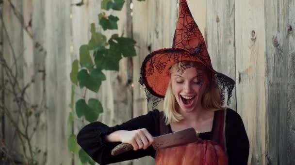 Šťastné Halloweenské děvče. Krásná mladá překvapená žena v čarodějnici a Halloweenské maškarní s dýní. Citové mladé ženy v kostýmech na Halloween. — Stock video
