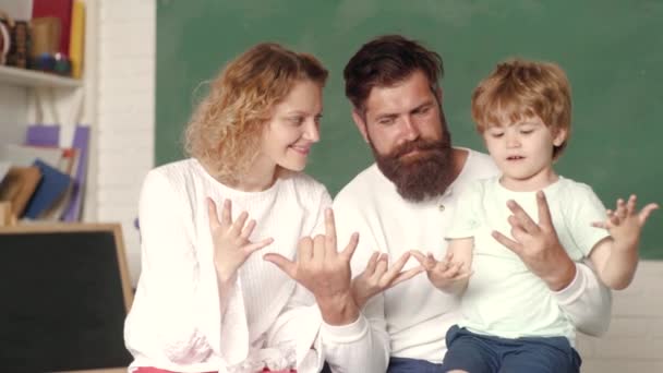 Cálculo de aprendizagem em dedos. Casal jovem ajudando seu filho a fazer os trabalhos de casa. Início das lições. Conceito escolar. Família feliz. Mulher e homem ajudam o menino. Primeira vez na escola . — Vídeo de Stock