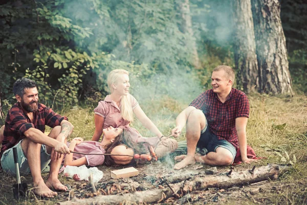 Amigos no acampamento com salsichas varas na floresta — Fotografia de Stock
