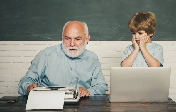 Dziadek rozmawia z wnukiem. Lubi rozmawiać z dziadkiem. Szczęśliwy dziadek z wnukiem do korzystania z laptopa. Nauczyciel pomaga swojemu nastoletni uczniowi w klasie edukacyjnej. — Zdjęcie stockowe