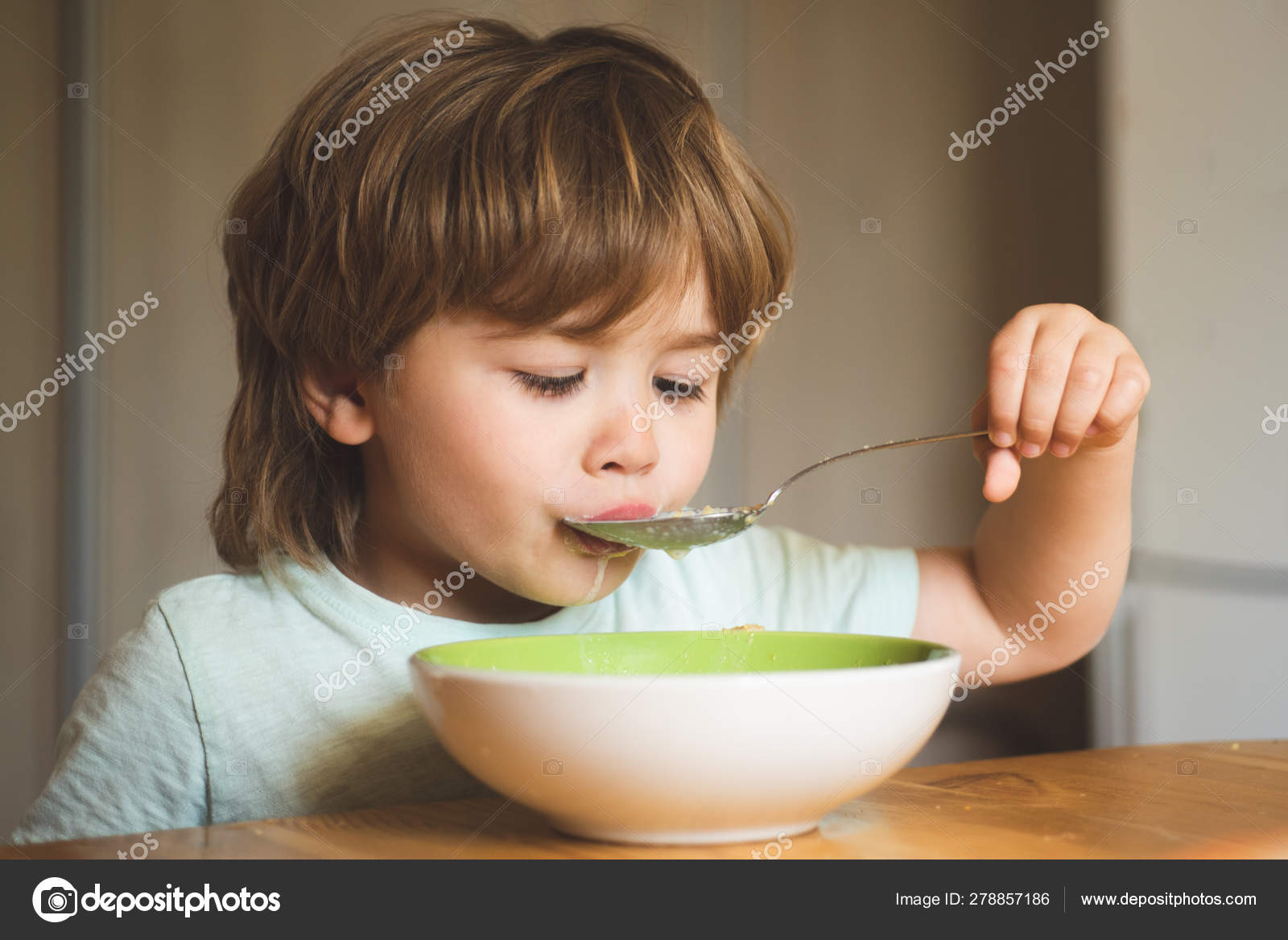 Laughing Cute Child Baby Boy Sitting In Highchair And Eating On