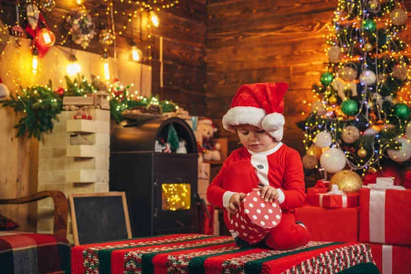 Счастливый ребенок с рождественской подарочной коробкой. Маленький мальчик в теплой одежде сидит и играет с деревянными игрушками подарок. Рождественское чудо и новогодние чувства. Открытые игры. Первое воспоминание о детстве . — стоковое фото