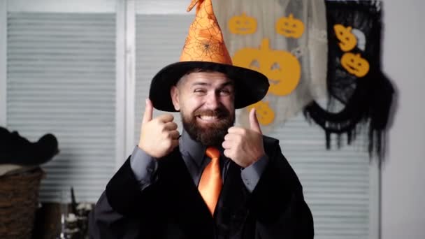 Wizard on Halloween. Funny wizard holds thumbs up. Thumbs up. Happy Halloween. Halloween costume and decoration, magic spell and sorcery concept. Bearded man in hat. Background. Halloween decorations. — Stock Video