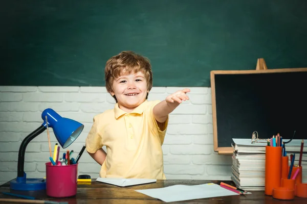 Jongen leerling van de basisschool op de school werf. Vrolijke glimlachende jongetje pupil plezier tegen Blackboard. Concept van onderwijs en lezen. Leraren dag. — Stockfoto