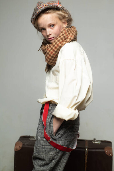 Confident in her perfect style. teen girl in retro suit. child in beret. street kid with dirty face. vintage english style. Travel with old suitcase. Homelss. retro fashion model. Vintage suspender