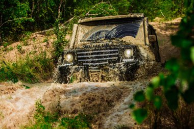 Dağ yolunda off-road seyahat. Çamur ve su sıçratıyor. Hareket tekerlekler lastikleri ve off-road toz gider.