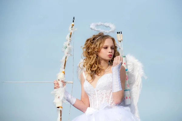 弓を持つキューピッドかわいい女の子。十代の天使無邪気な子供の概念。矢印と翼。天使の衣装白いドレスと羽の羽を着た幼児の女の子。かわいい十代の女の子 — ストック写真