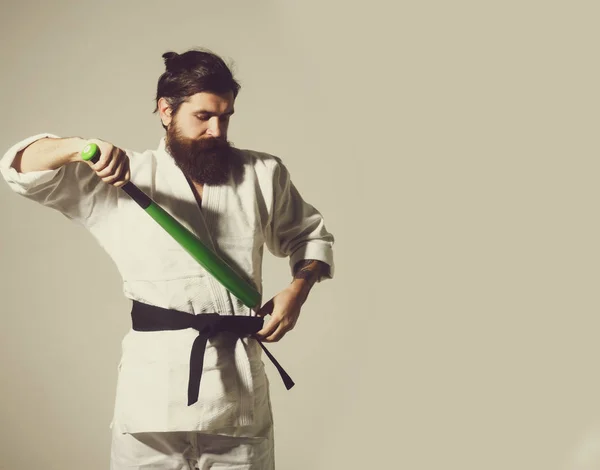 Skäggiga allvarliga karate man i kimono med gröna basebollträ — Stockfoto