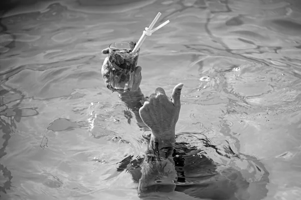 Mãos de turista segurando copo de coquetel mojito na beira da piscina . — Fotografia de Stock