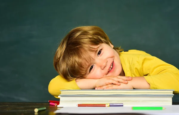 Koncepcja szkoły i edukacji. Uczeń lub przedszkolak się uczy. Edukacja. Szczęśliwi uśmiechnięci uczniowie rysujący przy biurku. Uczeń.. — Zdjęcie stockowe