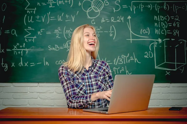 Студент с ноутбуком. Студентка смотрит в камеру. Веселая улыбающаяся студентка у доски. Концепция образования и кампуса . — стоковое фото