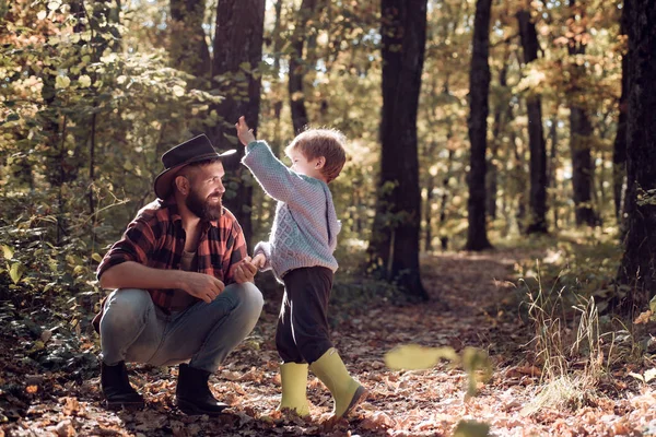 Brutal barbudo y niño disfrutan de la naturaleza otoñal. De ocio familiar. Valores familiares. Explora la naturaleza. Concepto de vagabundeo. Hipster padre barbudo con lindo hijo pasar tiempo juntos en el bosque. Tiempo en familia — Foto de Stock