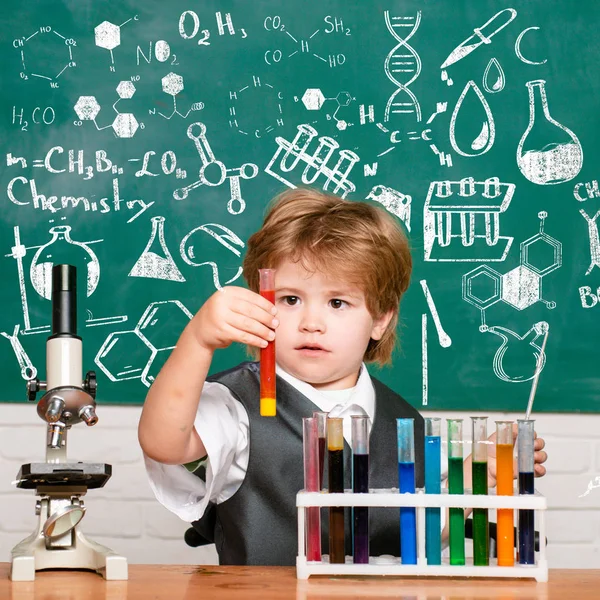 De genomförde ett nytt experiment i kemi. Kid lär sig i klass på bakgrund av Blackboard. — Stockfoto