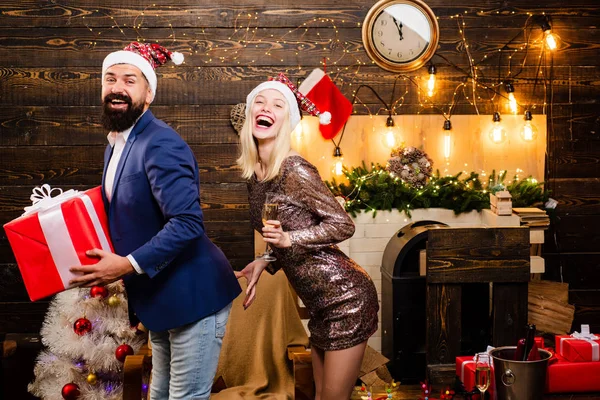 Christmas man suit fashion. Couple in love. Drunk Girls celebrate New Year. Christmas home interior. Cute young woman and handsome man with Santa dress.