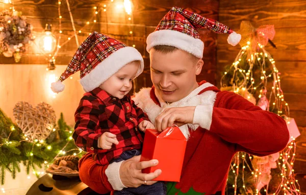 父と赤ちゃんの息子は家でクリスマスを祝います。冬休みのコンセプト。魔法の雰囲気の家族の休日。父上の喜び彼の息子とすべての瞬間をお楽しみください。一緒に休日を過ごす。家族愛 — ストック写真