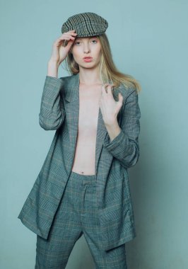 trendy bere. caz adım tarzı. İngiliz moda. damalı ceket ve bere. resmi erkek takım elbiseli zarif kadın. vintage bir görünüm. uzun saçlı retro güzel kız. doğal makyaj. güzellik ve zerafet
