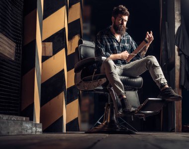 Berber dükkanında kuaförü ziyaret eden sakallı adam. Sandal ağacı tıraş kremi. Erkek müşteri kuaför tarafından saç kesimi oluyor.