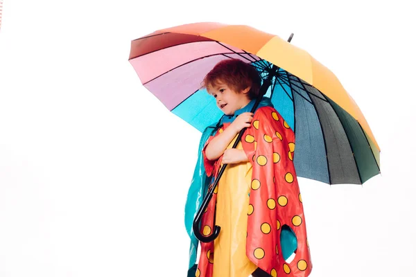 Venda para toda a coleção de outono, descontos incríveis e escolha maravilhosa. Menino bonito está se preparando para o outono. Menino alegre em capa de chuva com guarda-chuva colorido. Crianças a chover . — Fotografia de Stock