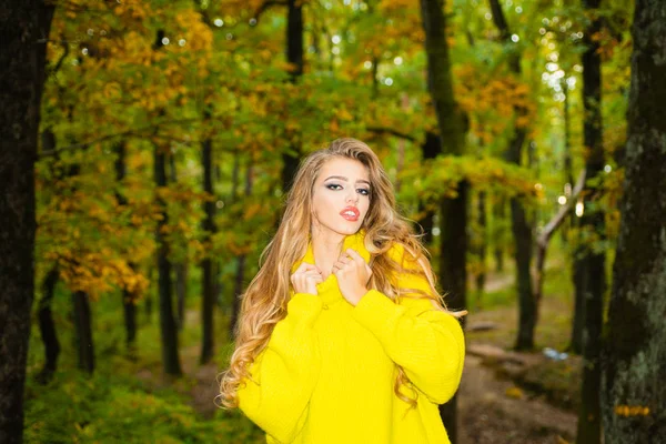 Осенняя женщина развлекается в парке и улыбается. Беззаботная молодая женщина в модном винтажном красном свитере или свитере. Красавица, гуляющая по парку и наслаждающаяся прекрасной осенней природой . — стоковое фото
