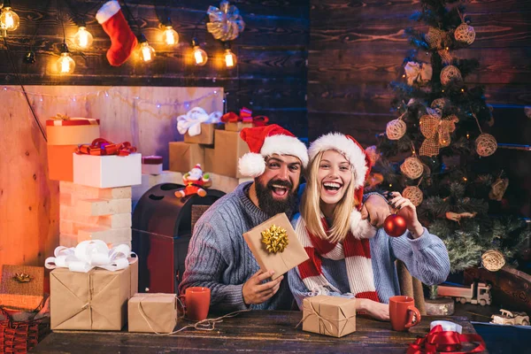 Vackra par klädda i en tomte hatt. Nyårskonceptet. Familjens jul är glada. God Jul och Gott Nytt År. Gott nytt år. Hoppy par över jul träd ljus bakgrund. — Stockfoto
