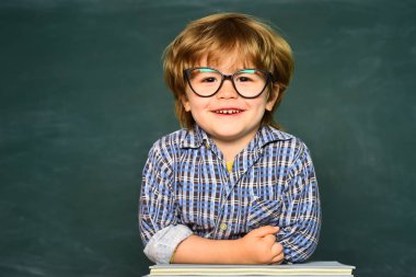 Çocuk tahtanın arka planında sınıfta öğreniyor. Evde öğrenmek. Mutlu okul çocukları. Eğitim süreci. Okula geri dön ve mutlu zamanları.