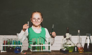 Ders Planları - Ortaokul Kimya. Okul dersindeki küçük çocuklar. Okul laboratuvarında kimya kazanan küçük çocuk bilim adamı. İlkokuldan gelen çocuk.