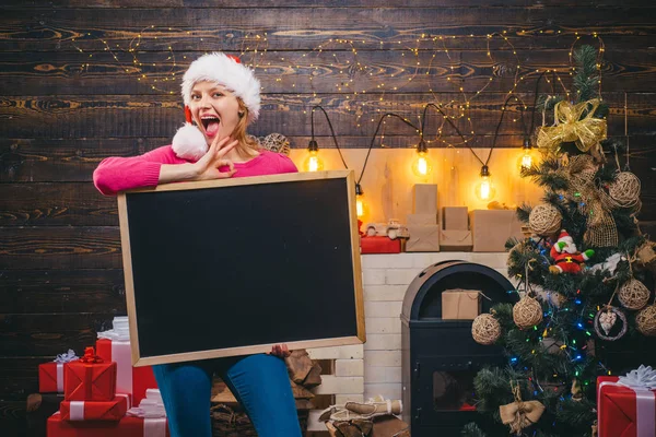 Noel Kadını mesaj için siyah bir masa tutuyor. Siyah tahta kopyalama alanı. Noel modası. Noel elbisesi giyen güzel bir kız. Noel hazırlığı. Lüks kız Yeni Yılı kutluyor. — Stok fotoğraf