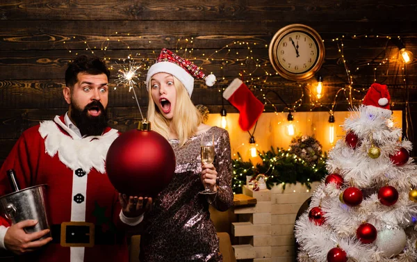 Χριστουγεννιάτικη διακόσμηση και κουτί δώρου σε ξύλινο φόντο. Πορτρέτο του ξαφνιασμένος και αστείο ζευγάρι. Κωμικό ζευγάρι: τρελό γιορτάζουμε. Σέξι γυναίκες του Hot Διασημότητες. — Φωτογραφία Αρχείου