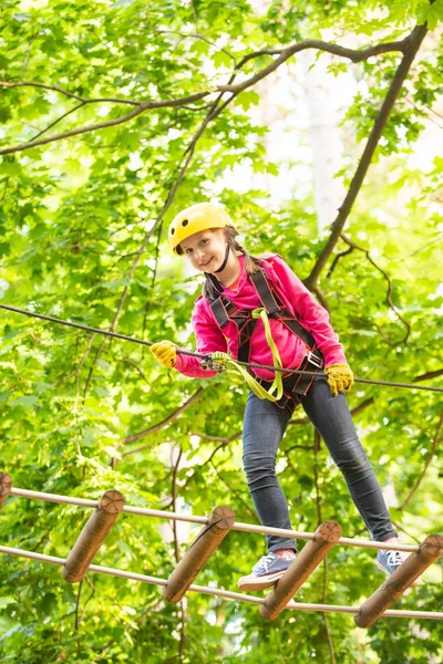 High ropes walk. Helmet - safety equipment for Child playing. Little child climbing in adventure activity park with helmet and safety equipment. Carefree childhood. — Stock Photo, Image
