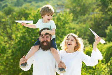 Mutlu neşeli aile eğlenmek havada küçük çocuk çocuk kusuyor. Anne baba ve oğul. Dost aile kavramı. Dışarıda eğlenen insanlar. Seyahat aile hayalleri.