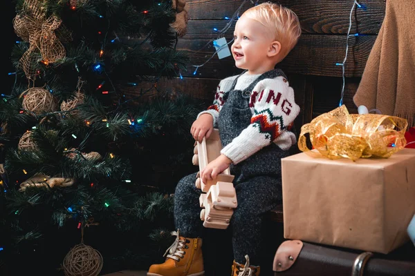 Niedliches kleines Kind in der Nähe des Weihnachtsbaums. Weihnachten Weihnachten Winterurlaub Konzept. Weihnachtsgeschichte. Weihnachtskinder. — Stockfoto