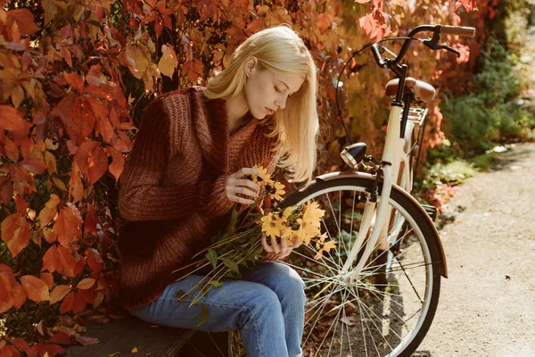 Blonde profiter parc de détente. Bouquet d'automne. Automne chaud. Fille avec vélo et fleurs. Femme vélo jardin d'automne. Loisirs actifs et mode de vie. Plaisirs simples d'automne. Fille vélo de promenade pour le plaisir — Photo