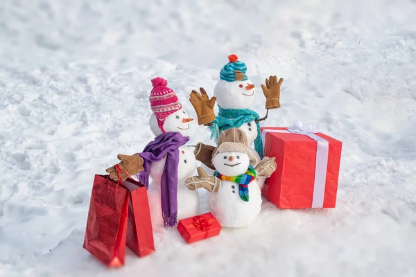 Regalos de entrega. Muñeco de nieve con regalo en Navidad. Muñeco de nieve con una bolsa de regalos. Familia muñeco de nieve en el fondo copos de nieve. Fondo de invierno con copos de nieve y muñeco de nieve. Snowmen Familia . —  Fotos de Stock