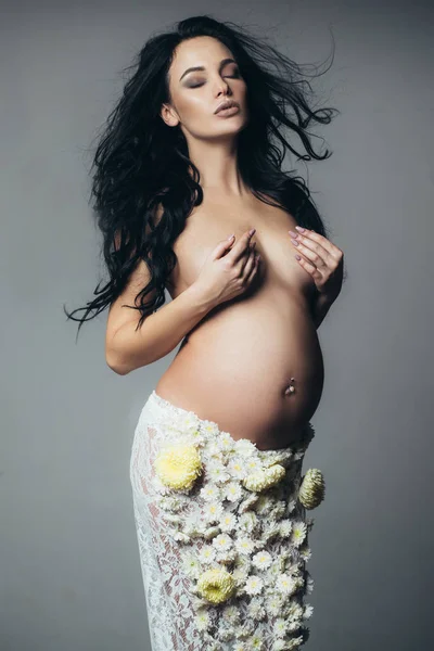 Espérance de vie naissance. L'amour. belle femme enceinte en jupe fleur de printemps. future mère a bébé à l'intérieur. santé des femmes. fille avec un gros ventre. grossesse. Préparation à la maternité. concept d'attente — Photo