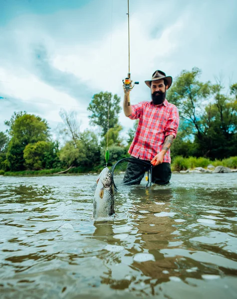 Fliegenfischen auf Forellen. Angeln im Fluss. fängt einen Fisch. Fang einen großen Fisch mit einer Angelrute. Fliegenfischen - Methode zum Forellenfang. — Stockfoto