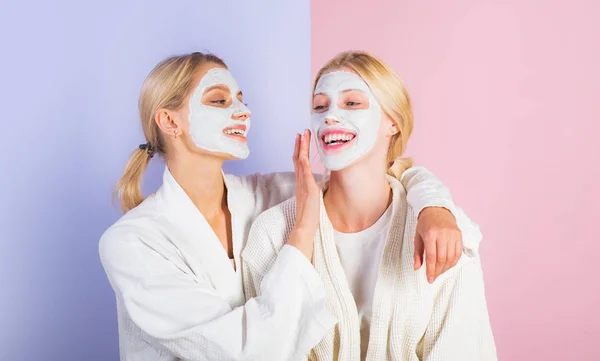 Meninas amigos, irmãs ou mãe e filha arrepiante fazendo máscara facial de barro. Máscara anti idade. Fica bonita. Cuidados da pele para todas as idades. Mulheres meninas muito sorridentes com máscara de barro. rotina de mimar — Fotografia de Stock