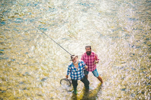 Pêche père et garçon ensemble. Truite brune. Pêcheur à la mouche sur la rivière. Père et fils se relaxent ensemble . — Photo