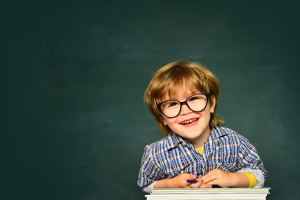 優れたマークで幸せな生徒の少年。学校と教育の概念。学用品付き机の近くで幸せそうな表情を持つ可愛い少年。最初の学校の日 — ストック写真