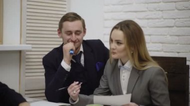 Kadın takım lideri masada oturan ve genç yaratıcı ekibe yön veriyor. Finansal uzman beyin fırtınası grubu. Çalışanlar finansal kârı tartışıyorlar. Grup finansörlerinin iş akışı.