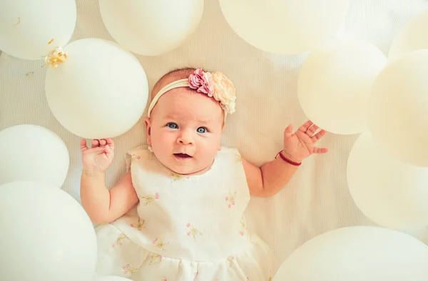 What else to do. Sweet little baby. New life and birth. Childhood happiness. Small girl. Happy birthday. Family. Child care. Childrens day. Portrait of happy little child in white balloons — Stock Photo, Image