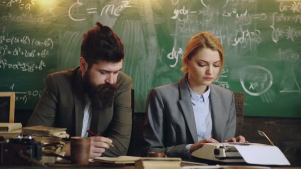 Disziplinkonzept. Mann mit Bart hält Stift und sexy Lehrermädchen-Drucke auf Schreibmaschine, Kreidetafel im Hintergrund. Lehrerin und strenge Schulleiterin achten auf Disziplin und Regeln in der Schule. — Stockvideo