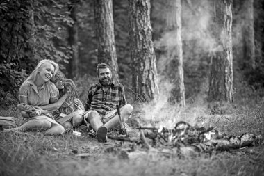 Kampta kitap okuma retro elbise genç güzel kız. Esmer sarışın kız kardeşi oturan adam sakallı iken sarılma kıvırcık saçlı gülümseyerek. Dostluk, Aile ve eğlence kavramları