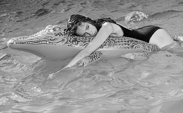 豪華なスイミング プールでおくつろぎください。ファッションのワニ革と水の中の少女夏休み、海、モルディブへの旅行。ワニの女の子の冒険。膨脹可能なマットレスと海の女性. — ストック写真