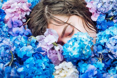 Yaz güzelliği. Makyaj kozmetik ve cilt bakımı. Ortanca çiçekleri olan bahar kadını. Kadının moda portresi. Sağlıklı saç ve cilt. yaz makyajlı kız. Bahar gününün tadını çıkarıyor