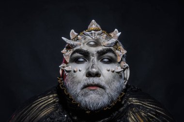 Siyah arka planda iblis kafası. Keskin dikenler ve siğiller, büyü ve fantezi kavramı ile Yabancı veya sürüngen makyaj. Geleceği öngören beyaz gözlü kör adam, kehanet büyücüsü