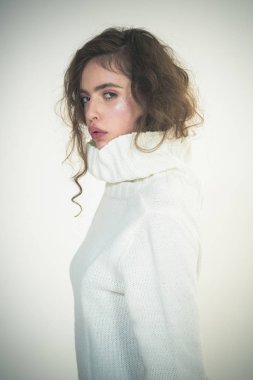 Güzel yüzünde makyajlı bir kız. Güzellik ve kuaför. Beyaz kış kazak şık saçlı trendy kadın. Yumuşak ciltli model için makyaj. Moda görünüm kavramı. Trendy arıyorsunuz.