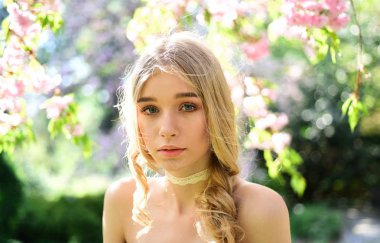 Güzel sevimli ihale genç sarışın kız gül bahçesinde çiçekli ağaçlarda nazik muhteşem renkler Lady güneşli bahar günü Şefkat kavramı parkta yürür Genç kadın bahçede doğanın tadını çıkarın