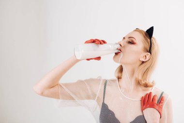 Kedi kadın gibi cam şişeden süt içen genç kız.